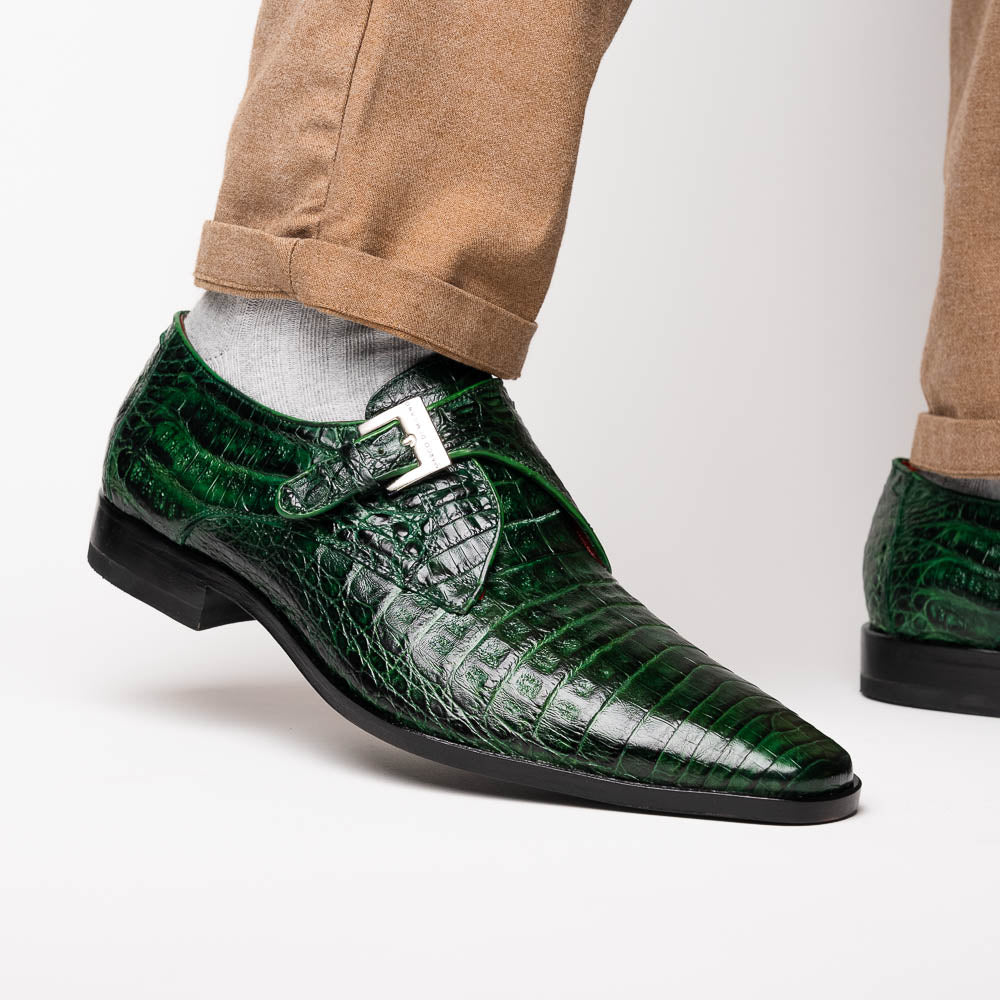 The Marco Di Milano Rovigo Forest Green features genuine caiman crocodile leather and a luxury monk strap, with one dress shoe propped to reveal its sole—a bold statement among men's exotic dress shoes.