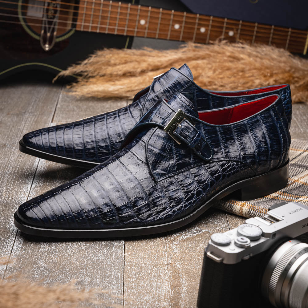 The Marco Di Milano Rovigo Navy features dark blue genuine caiman crocodile monk strap dress shoes with a silver buckle—one upright, the other on its side to display the sole—ideal for luxury men's footwear enthusiasts.