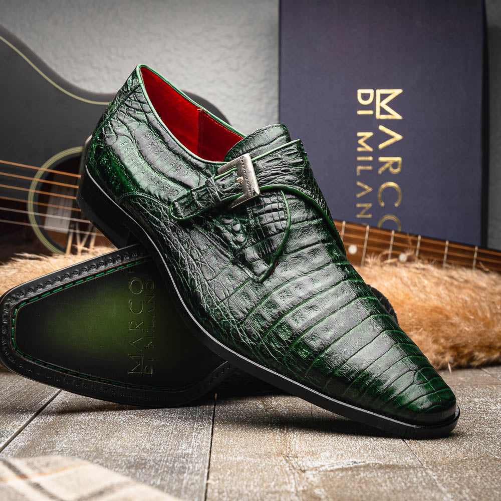 The Marco Di Milano Rovigo Forest Green features genuine caiman crocodile leather and a luxury monk strap, with one dress shoe propped to reveal its sole—a bold statement among men's exotic dress shoes.