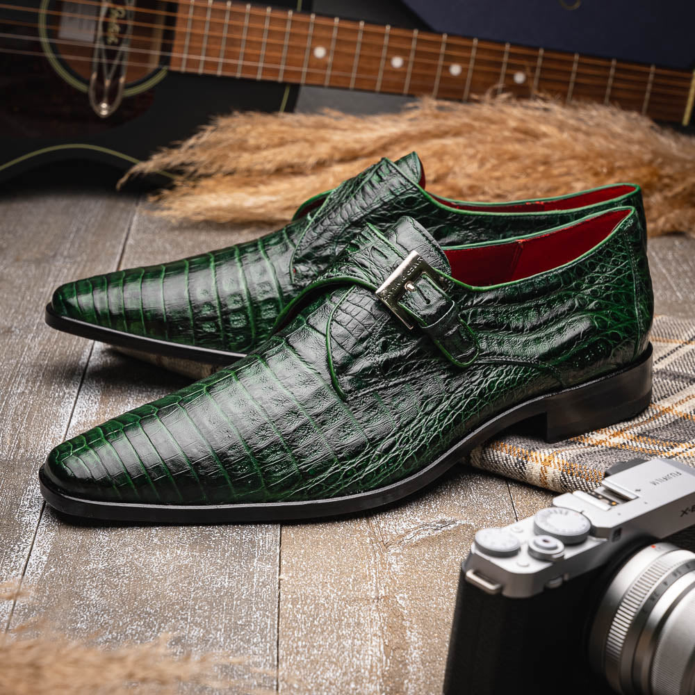 The Marco Di Milano Rovigo Forest Green features genuine caiman crocodile leather and a luxury monk strap, with one dress shoe propped to reveal its sole—a bold statement among men's exotic dress shoes.