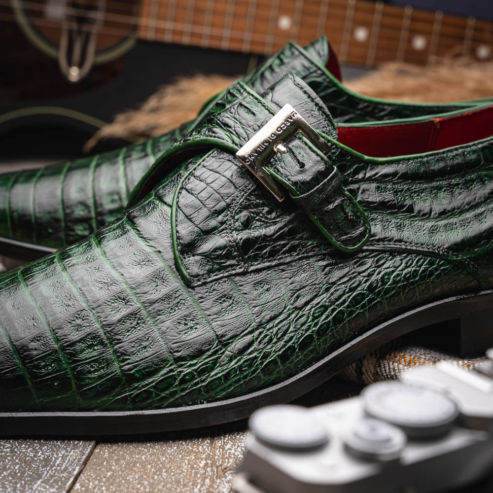 The Marco Di Milano Rovigo Forest Green features genuine caiman crocodile leather and a luxury monk strap, with one dress shoe propped to reveal its sole—a bold statement among men's exotic dress shoes.