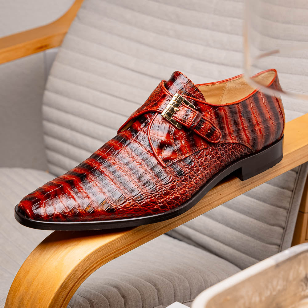 The Rovigo Cognac Straps by Marco Di Milano are brown genuine caiman crocodile monk strap dress shoes with a metal buckle—one upright, one on its side showing the branded sole. Luxury footwear for refined taste.