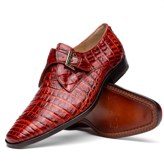 A pair of Rovigo Rustic Cognac monk strap dress shoes by Marco Di Milano, featuring shiny genuine caiman crocodile leather with a side buckle; one shoe is upright, and the other lies with its sole facing up.