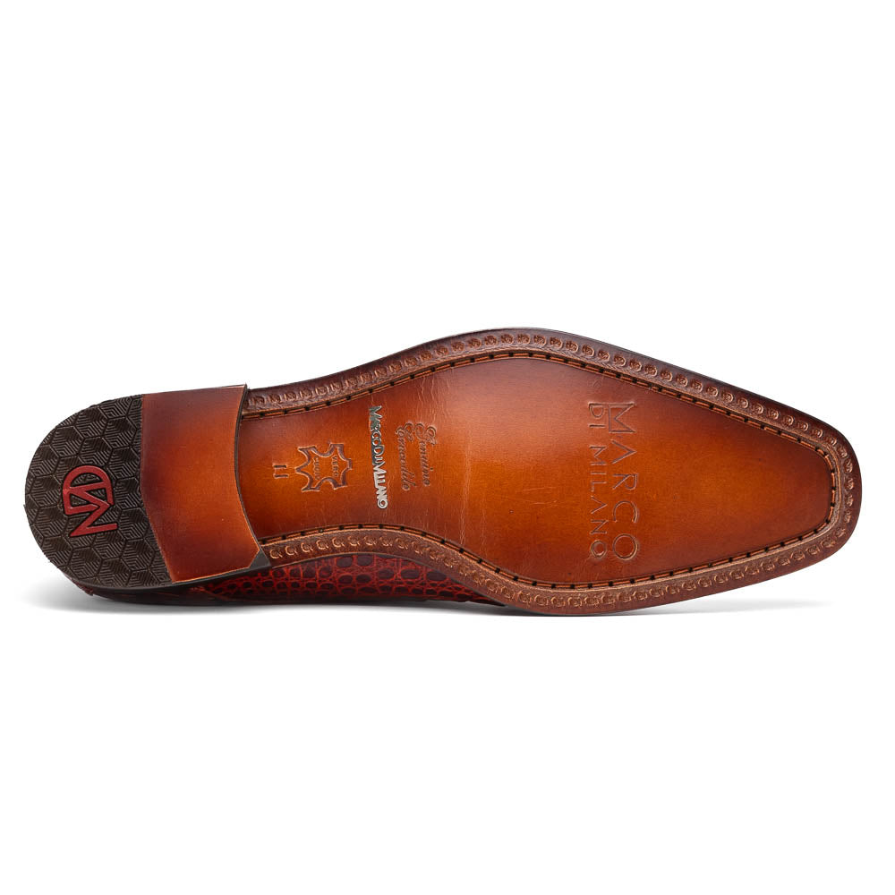 A pair of Rovigo Rustic Cognac monk strap dress shoes by Marco Di Milano, featuring shiny genuine caiman crocodile leather with a side buckle; one shoe is upright, and the other lies with its sole facing up.