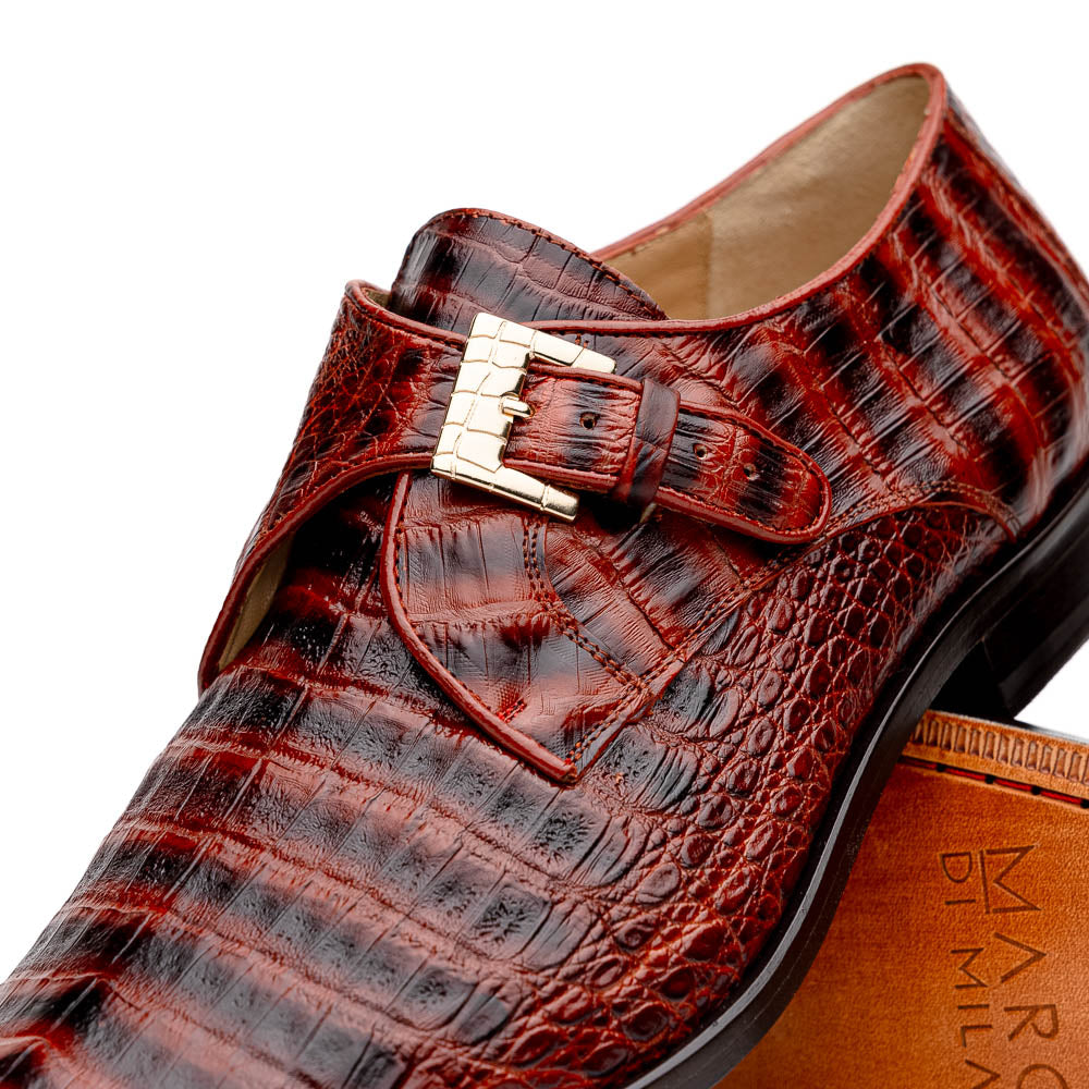 The Rovigo Cognac Straps by Marco Di Milano are brown genuine caiman crocodile monk strap dress shoes with a metal buckle—one upright, one on its side showing the branded sole. Luxury footwear for refined taste.