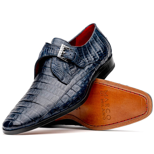 The Marco Di Milano Rovigo B Navy is a luxury men's monk strap shoe in blue crocodile-pattern leather, with one shoe upright and the other showing a tan sole stamped with the brand logo—perfect for dress shoe aficionados.