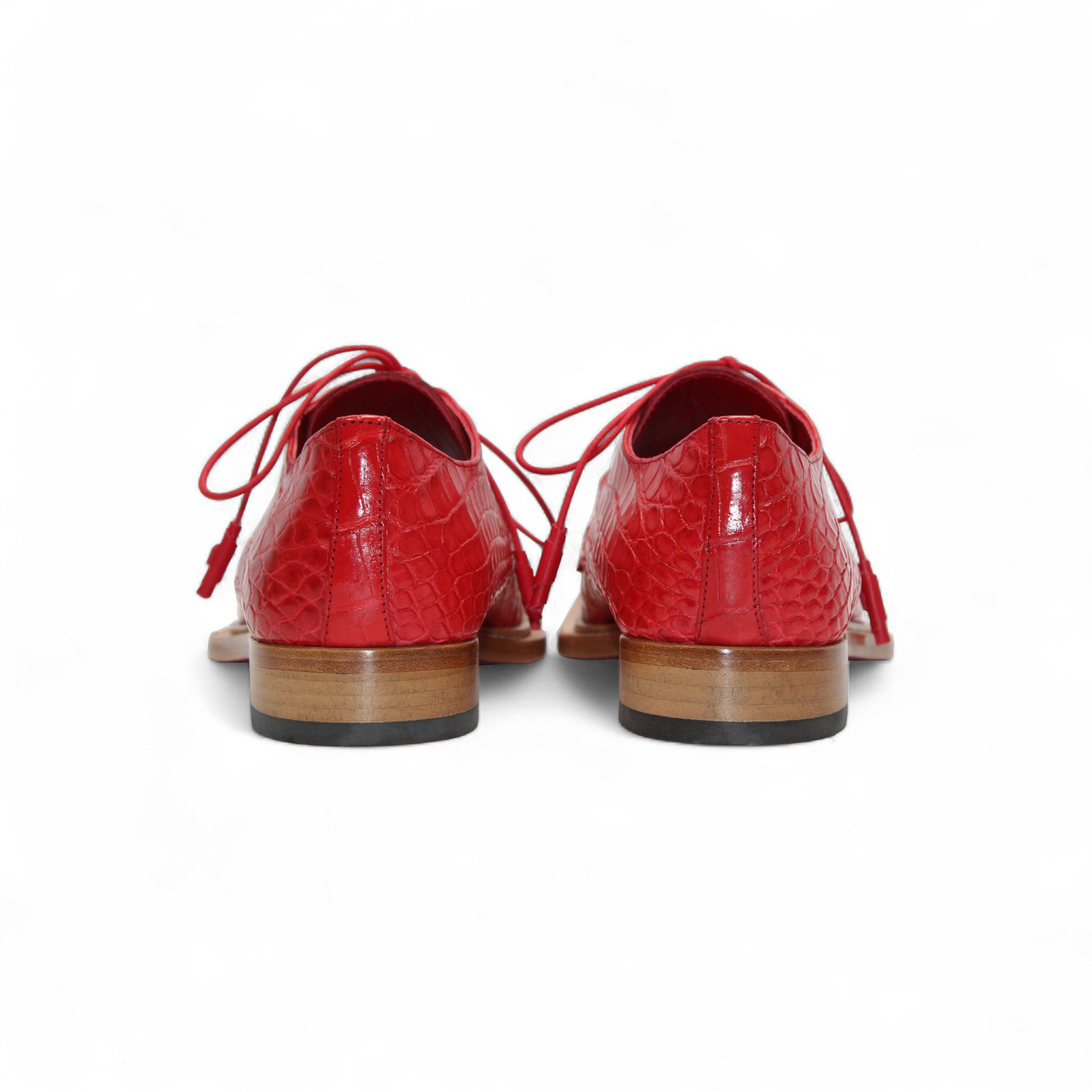 The Fennix Rowan Red by Fennix of Italy—a single red oxford crafted from genuine alligator leather with laces and a light brown wooden sole—is displayed in side profile against a white background, perfect for any luxury shoe collection.