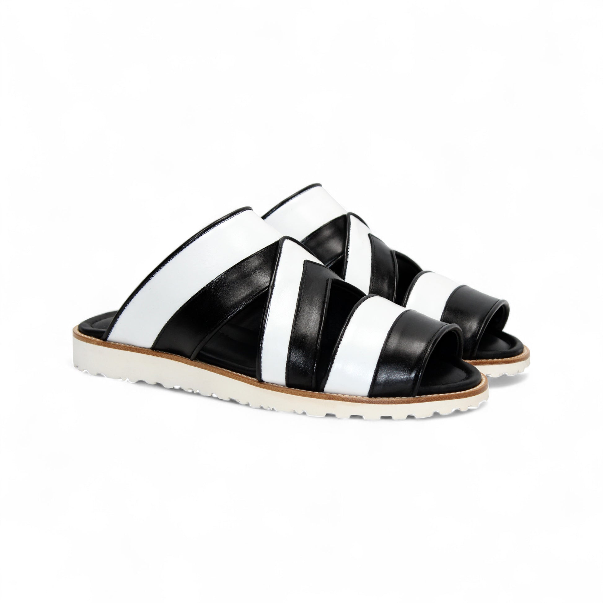 The Duca Di Matiste Duca SA118 Black/White slip-on sandal features crisscross straps and a flat, ridged sole, shown from the side on a white background—showcasing modern Italian-inspired shoe design.