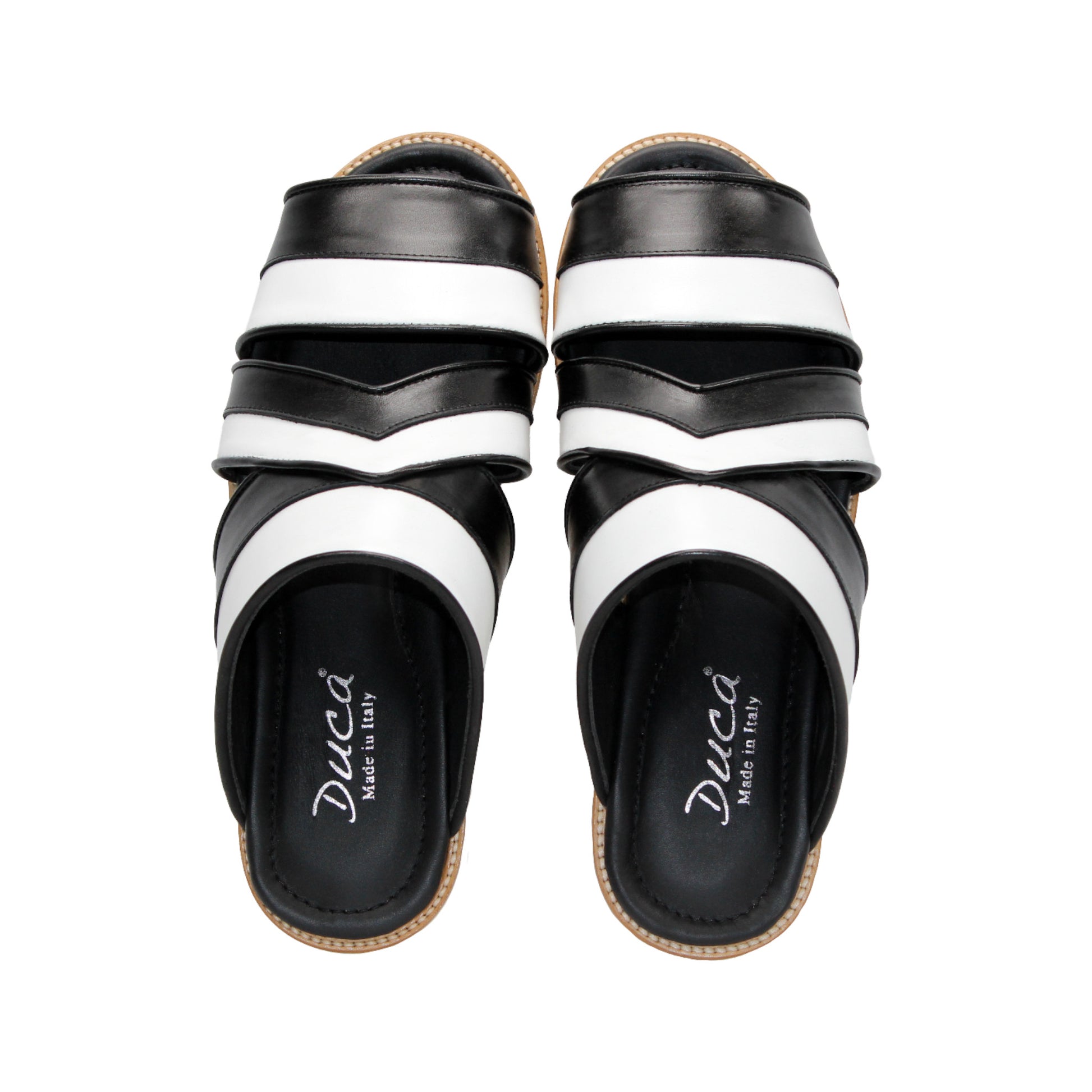 The Duca Di Matiste Duca SA118 Black/White slip-on sandal features crisscross straps and a flat, ridged sole, shown from the side on a white background—showcasing modern Italian-inspired shoe design.