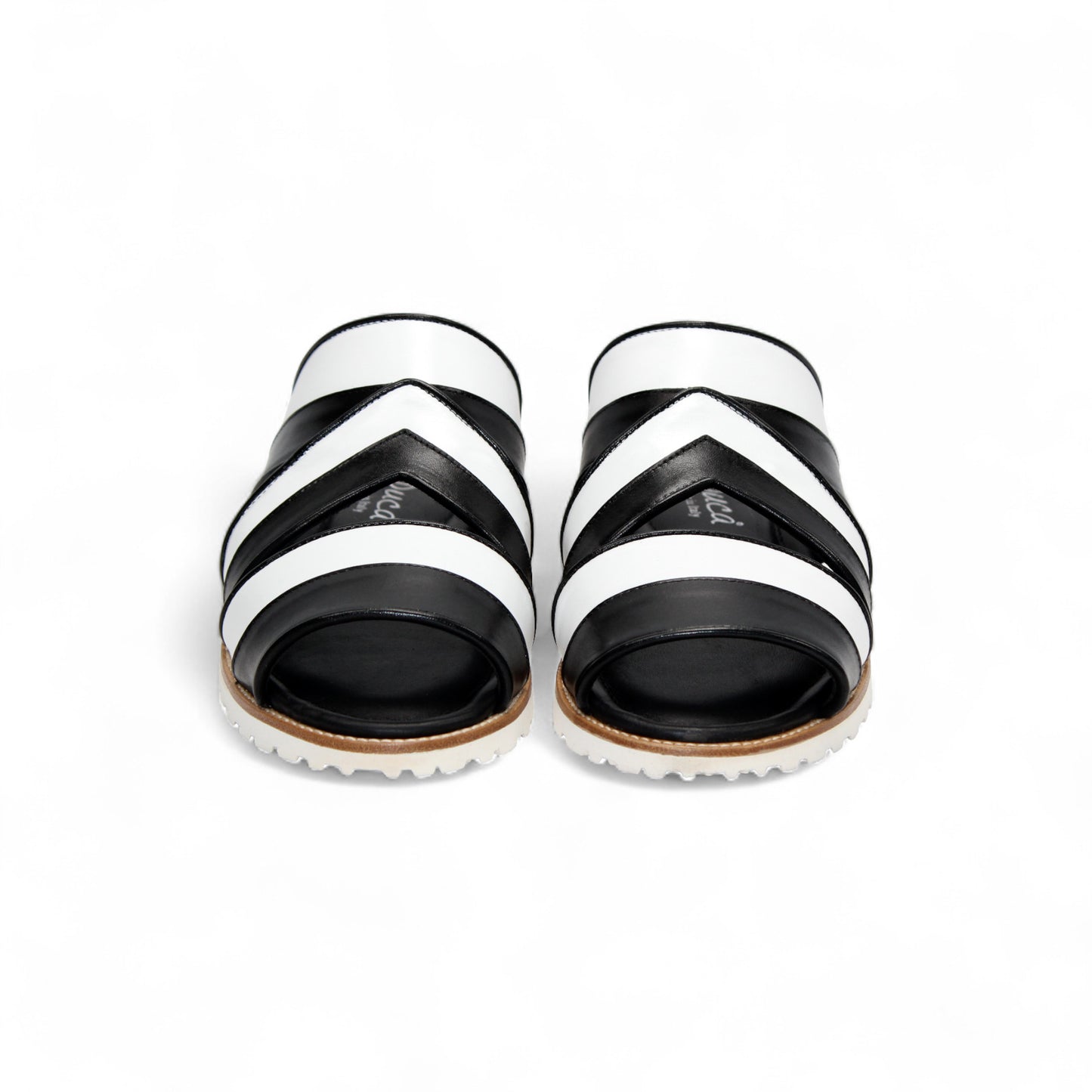 The Duca Di Matiste Duca SA118 Black/White slip-on sandal features crisscross straps and a flat, ridged sole, shown from the side on a white background—showcasing modern Italian-inspired shoe design.