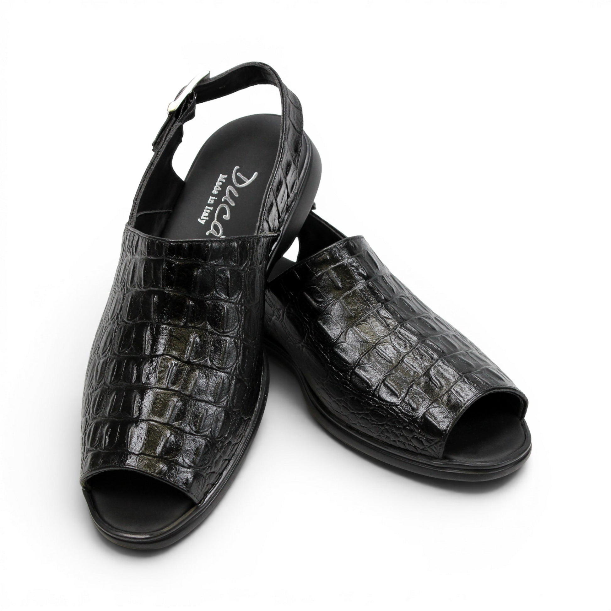 The Duca Di Matiste Duca SA136 Black sandal features faux-crocodile texture, open toe, closed back, adjustable buckle strap, and flat sole. Shown in side view on a white background.