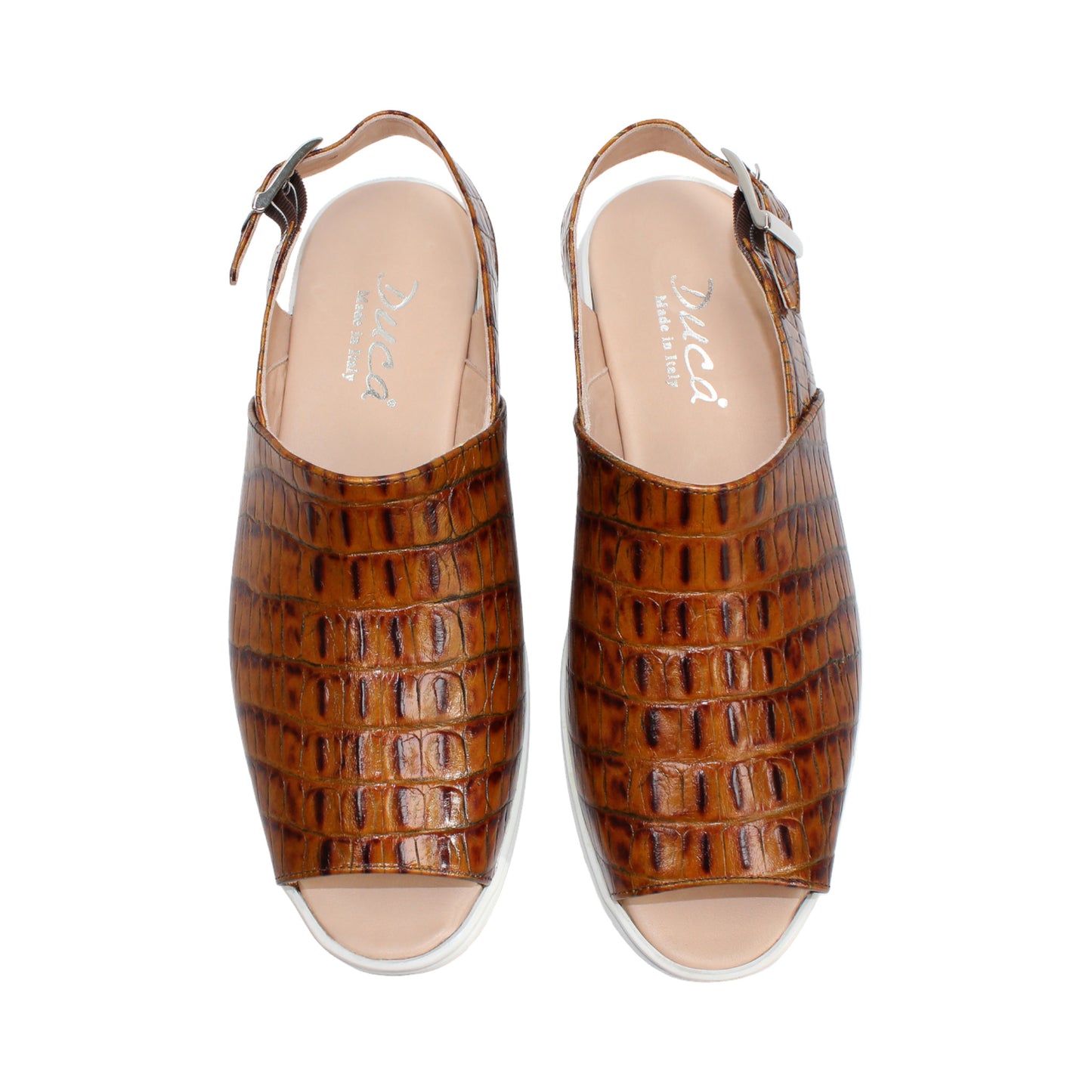 The Duca Di Matiste Duca SA136 Cognac sandal features brown crocodile-patterned calf leather, a closed toe, adjustable buckle strap, and white flat sole for modern comfort, shown on a white background.