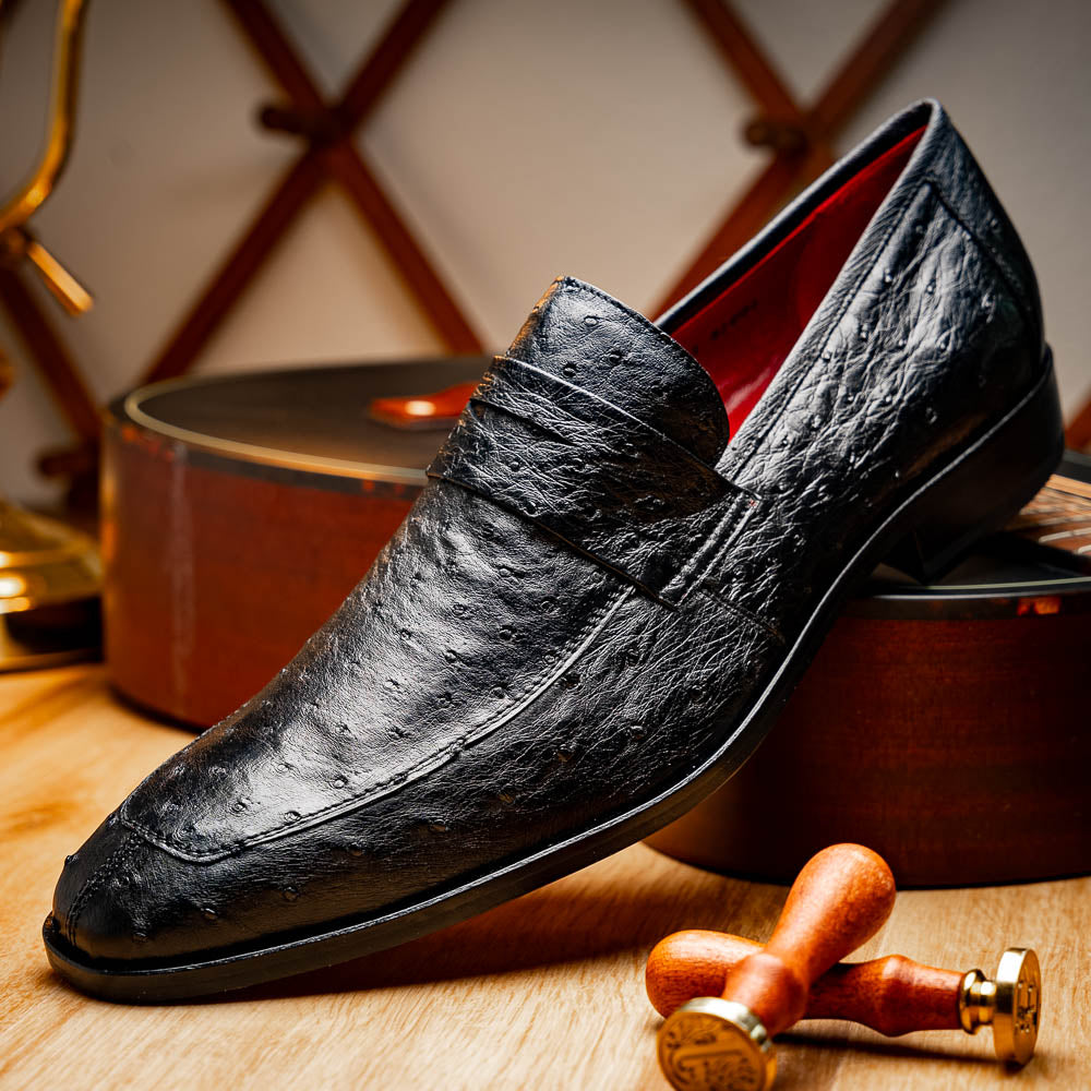 The Salvatore Black by Marco Di Milano is a pair of genuine ostrich leather loafers in black with a brown leather sole, detailed stitching, and an embossed brand logo on the outsole—ideal for luxury footwear enthusiasts.