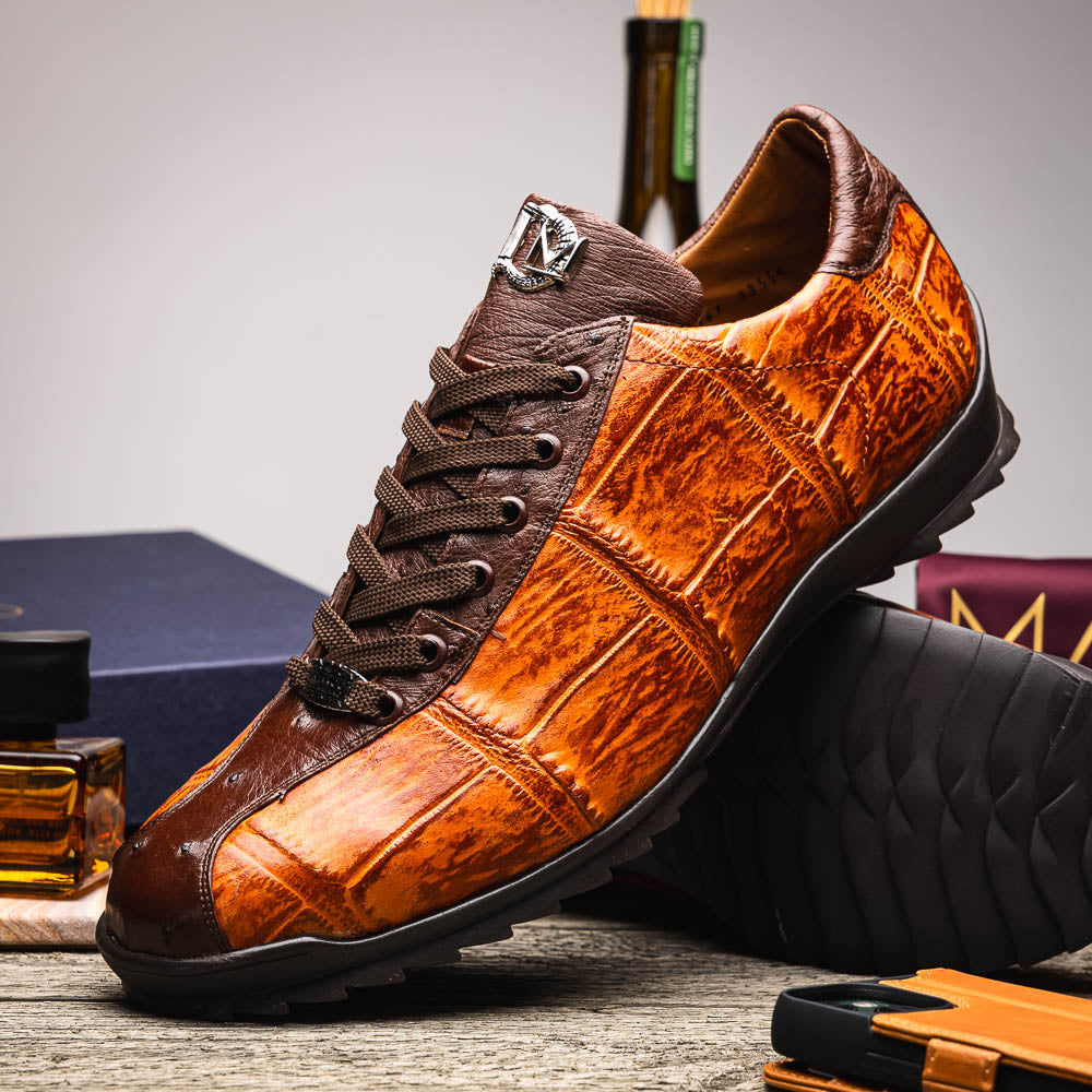 The Saulo Brandy / Brown sneakers by Marco Di Milano feature genuine brown alligator, black soles, dark brown laces, and metallic logo accents—luxury men's footwear displayed against a white background.