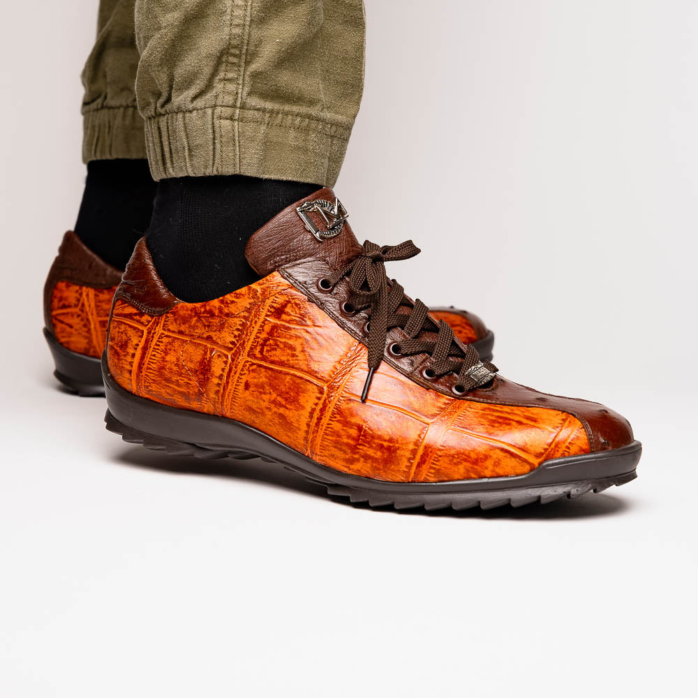 The Saulo Brandy / Brown sneakers by Marco Di Milano feature genuine brown alligator, black soles, dark brown laces, and metallic logo accents—luxury men's footwear displayed against a white background.