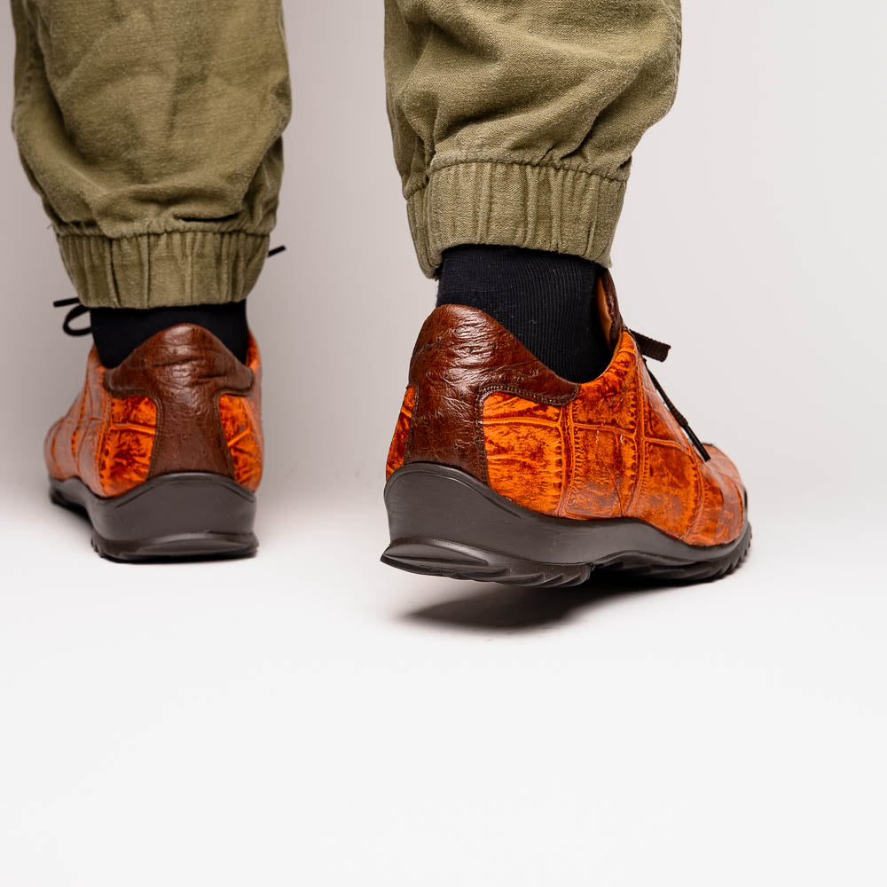 The Saulo Brandy / Brown sneakers by Marco Di Milano feature genuine brown alligator, black soles, dark brown laces, and metallic logo accents—luxury men's footwear displayed against a white background.