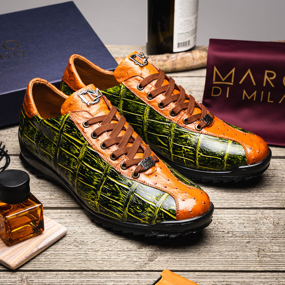 The Saulo Green / Cognac by Marco Di Milano is a luxury men's sneaker with an orange and green crocodile pattern, brown laces, black sole, and metallic tongue emblem—ideal for those wanting an authentic alligator look.