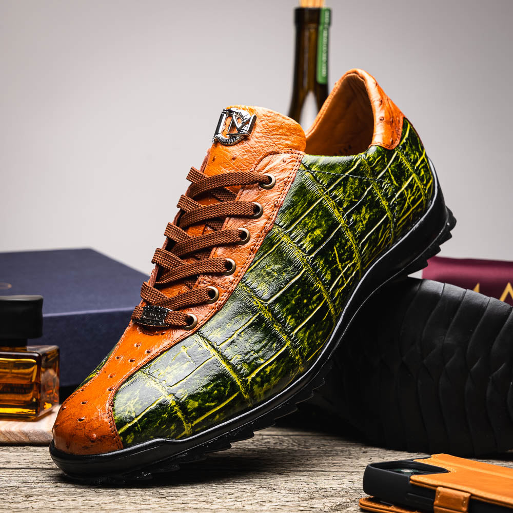 The Saulo Green / Cognac by Marco Di Milano is a luxury men's sneaker with an orange and green crocodile pattern, brown laces, black sole, and metallic tongue emblem—ideal for those wanting an authentic alligator look.