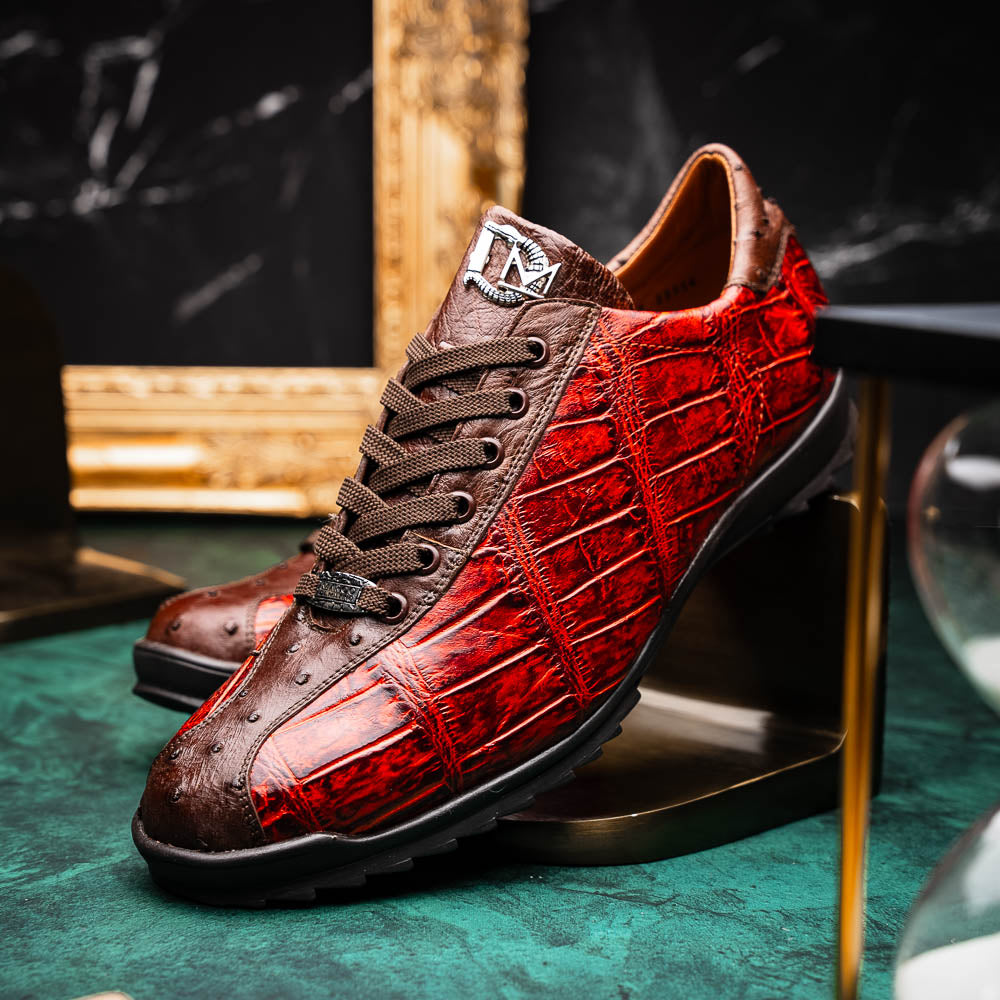 The Saulo Cognac sneakers by Marco Di Milano feature genuine alligator leather in red and brown with black laces and soles—an exceptional luxury men's footwear choice, shown with one upright and the other lying on its side.