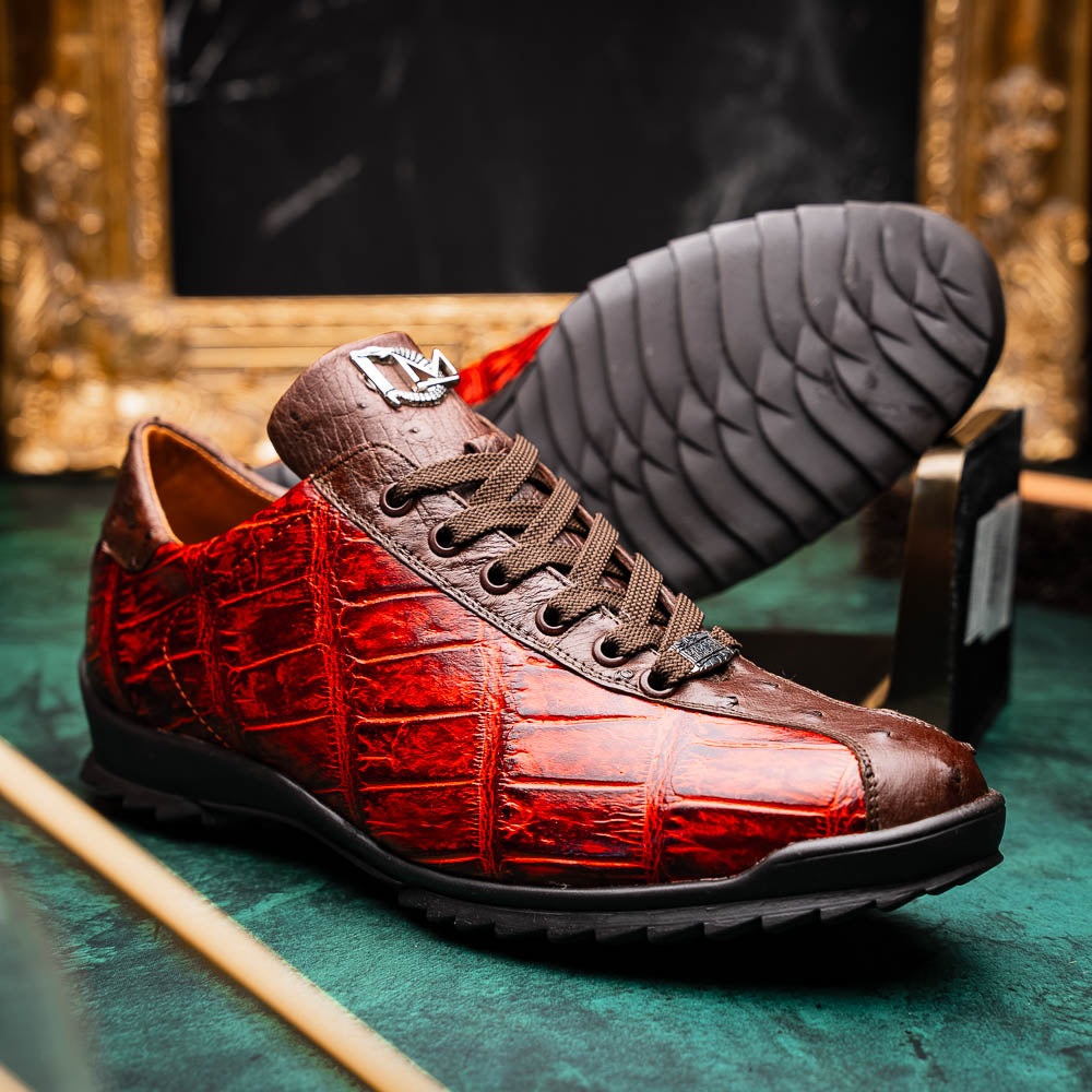 The Saulo Cognac sneakers by Marco Di Milano feature genuine alligator leather in red and brown with black laces and soles—an exceptional luxury men's footwear choice, shown with one upright and the other lying on its side.