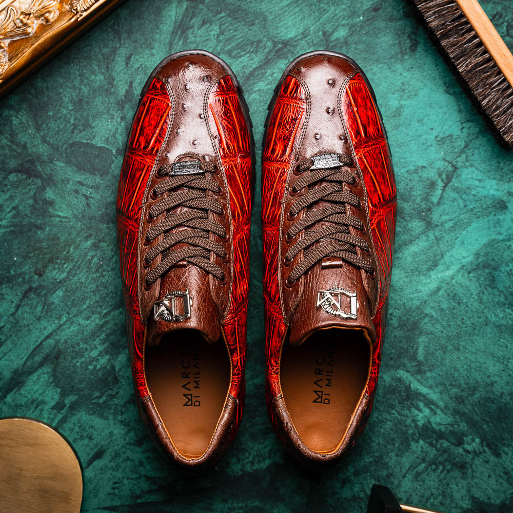 The Saulo Cognac sneakers by Marco Di Milano feature genuine alligator leather in red and brown with black laces and soles—an exceptional luxury men's footwear choice, shown with one upright and the other lying on its side.