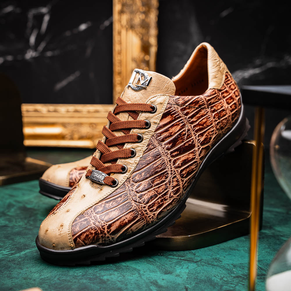 A pair of Saulo Orix men's shoes by Marco Di Milano, featuring brown crocodile-pattern leather and black rubber soles; one shoe stands upright while the other leans against it.
