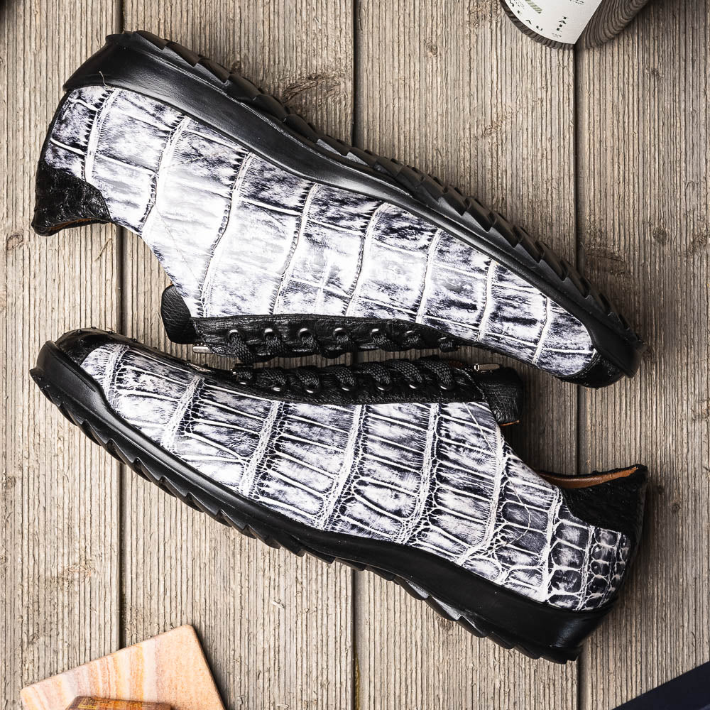 The Saulo Newspaper / Black sneakers by Marco Di Milano are luxury men's shoes featuring a black and white crocodile pattern, black laces, and a textured sole, showcased on a white background.