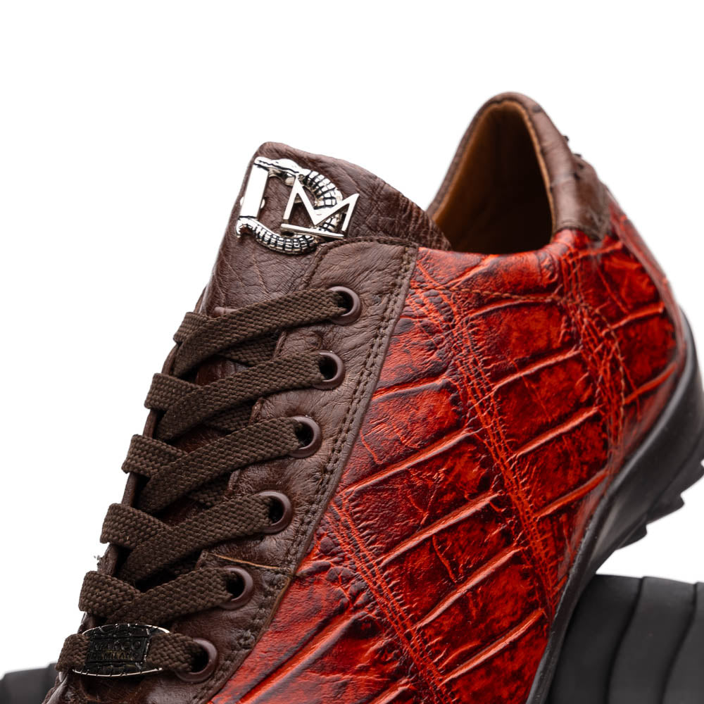 The Saulo Cognac sneakers by Marco Di Milano feature genuine alligator leather in red and brown with black laces and soles—an exceptional luxury men's footwear choice, shown with one upright and the other lying on its side.