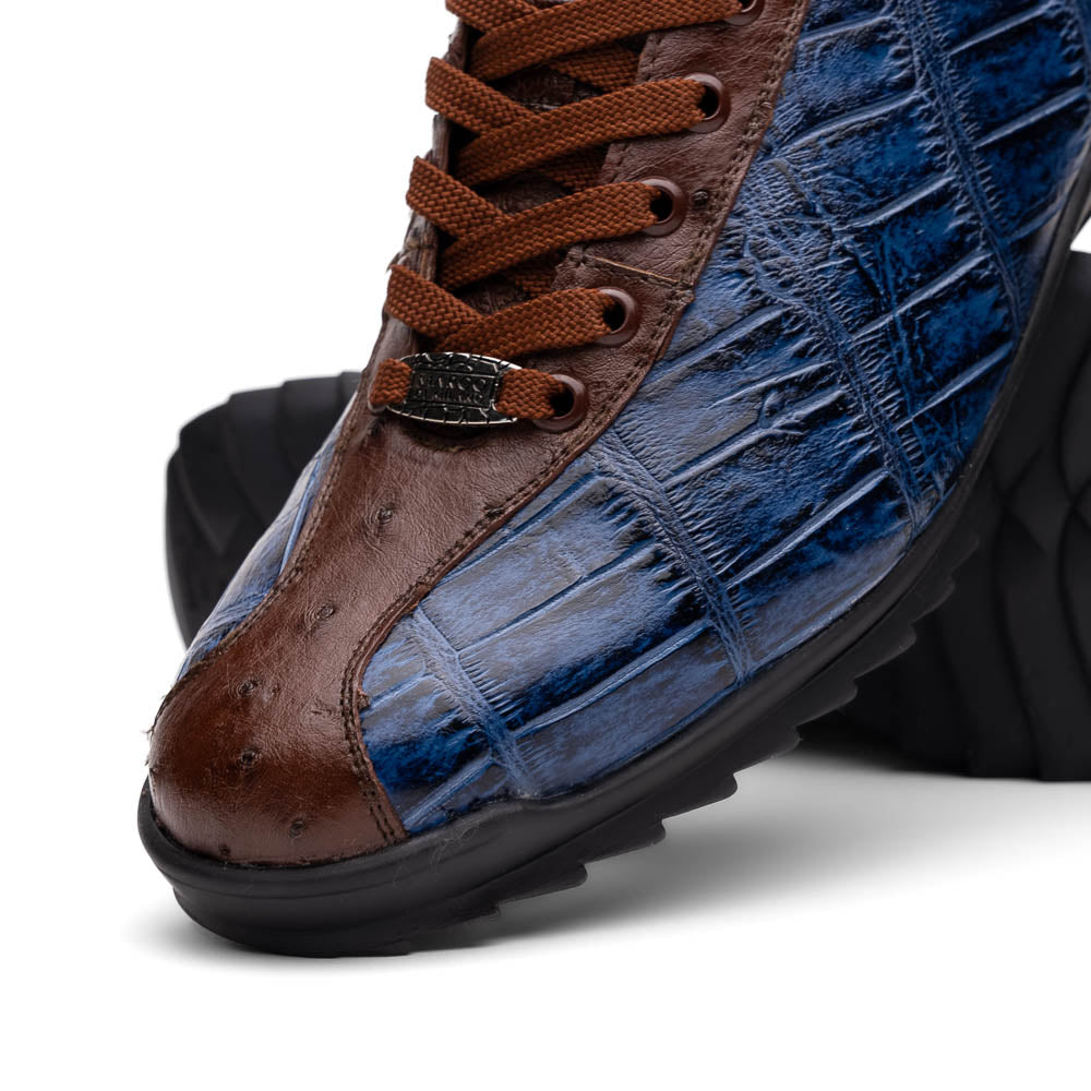 The Marco Di Milano Saulo Blue Jeans is a luxury men's sneaker featuring blue and brown hues, a textured crocodile-like pattern, and a black rubber sole, shown with one shoe upright and the other on its side.