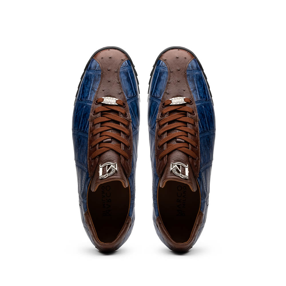 The Marco Di Milano Saulo Blue Jeans is a luxury men's sneaker featuring blue and brown hues, a textured crocodile-like pattern, and a black rubber sole, shown with one shoe upright and the other on its side.
