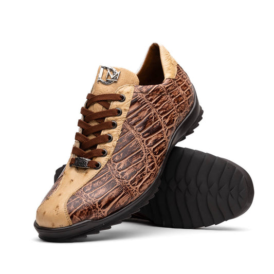 A pair of Saulo Orix men's shoes by Marco Di Milano, featuring brown crocodile-pattern leather and black rubber soles; one shoe stands upright while the other leans against it.