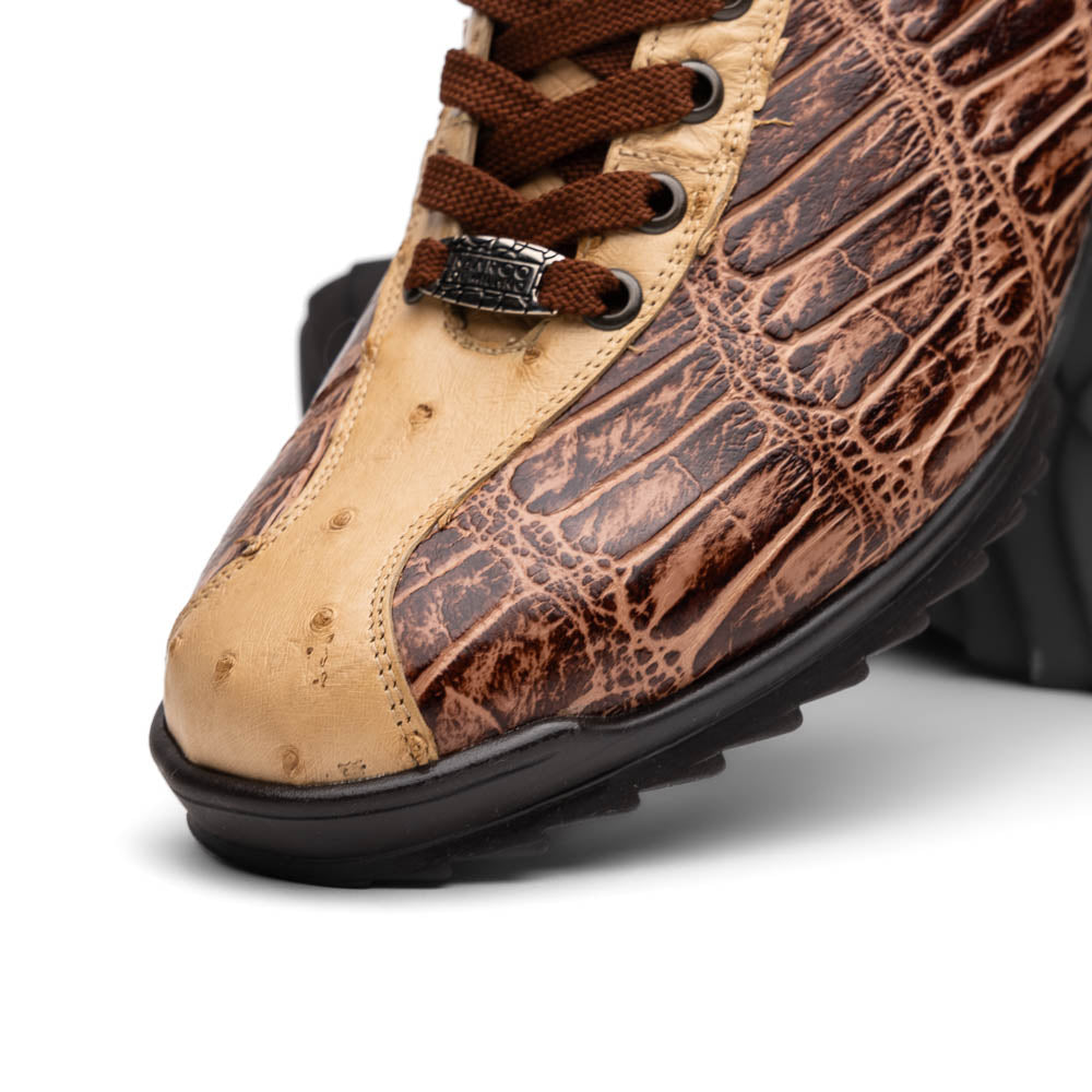 A pair of Saulo Orix men's shoes by Marco Di Milano, featuring brown crocodile-pattern leather and black rubber soles; one shoe stands upright while the other leans against it.