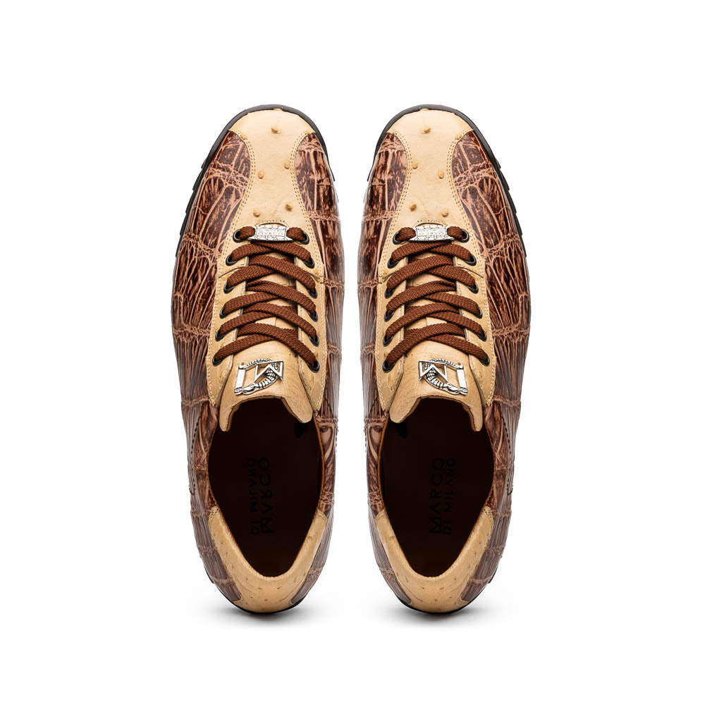 A pair of Saulo Orix men's shoes by Marco Di Milano, featuring brown crocodile-pattern leather and black rubber soles; one shoe stands upright while the other leans against it.