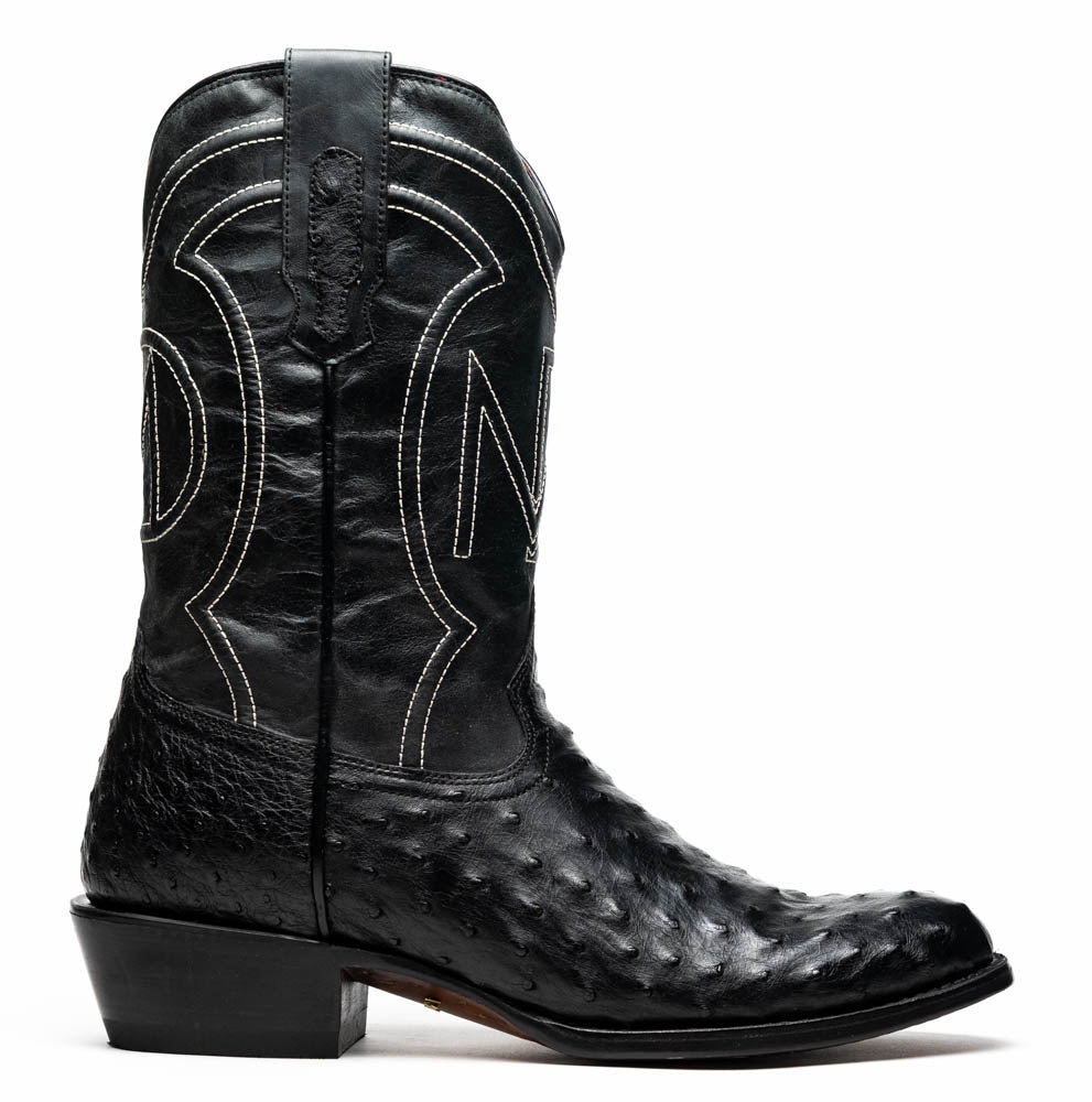 A pair of handcrafted Savannah Black western boots by Marco Di Milano; one boot stands upright while the other lies on its side, displaying a branded sole with "Marco Di Milano.