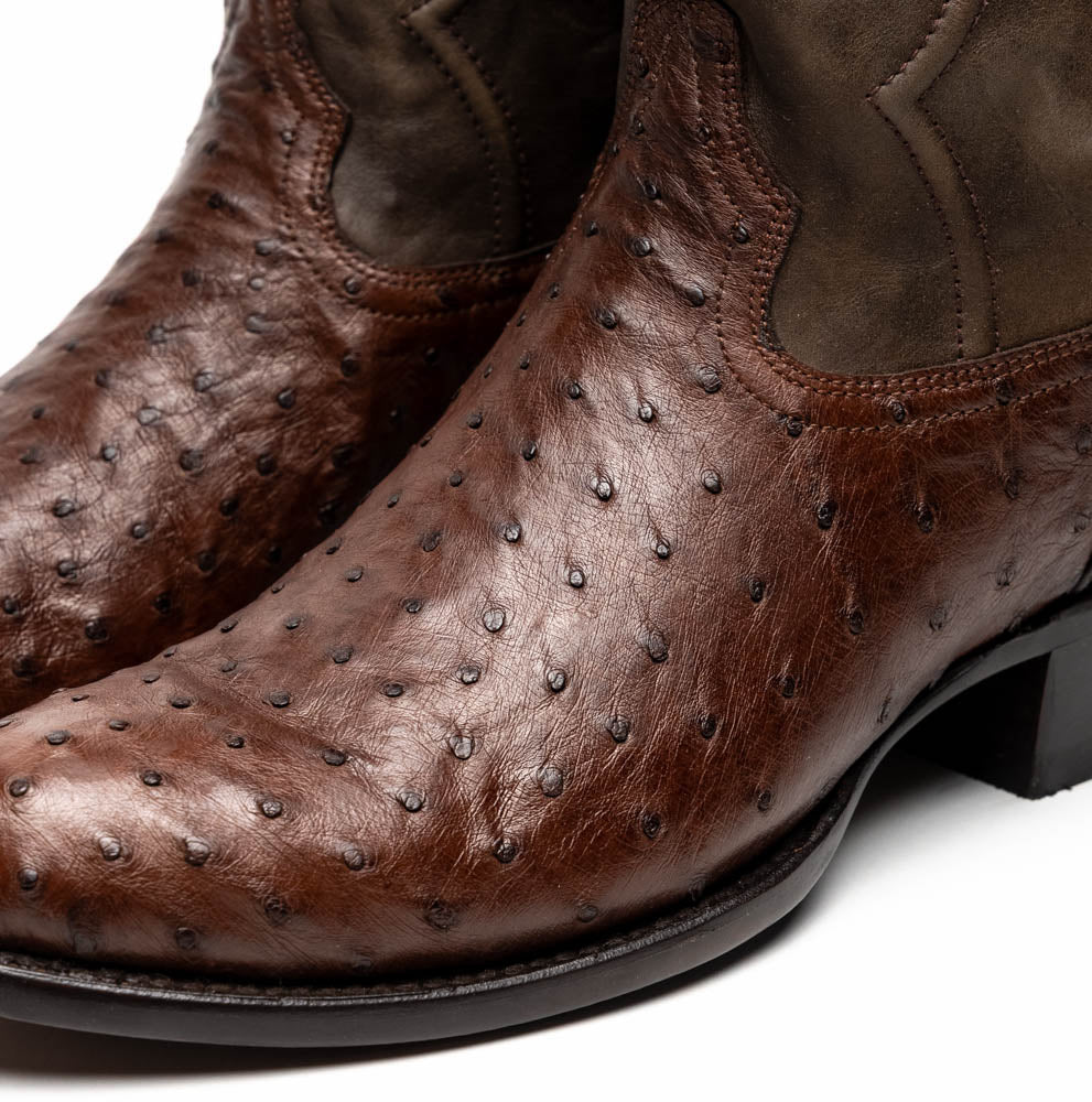 A pair of Marco Di Milano Savannah Kango Tabac boots in brown full-quill ostrich leather, one upright and the other on its side revealing the sole with the "Marco Di Milano" logo.