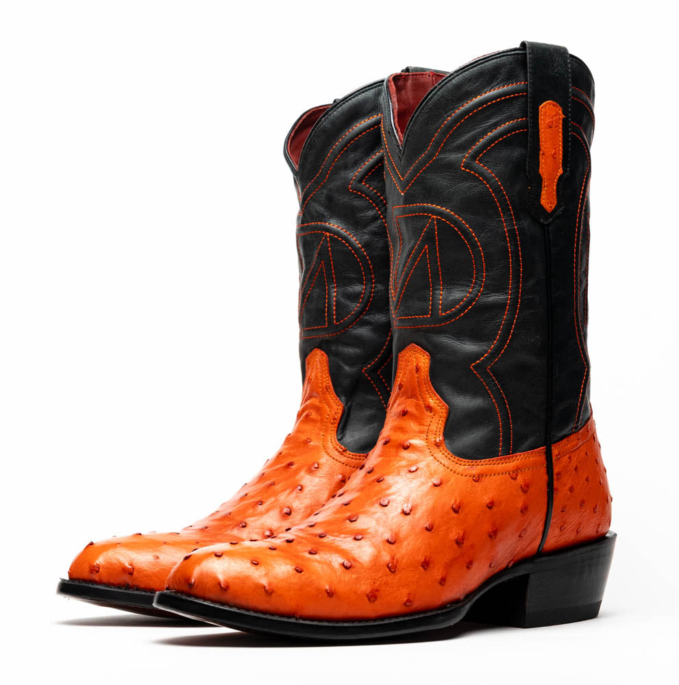 The Savannah Orange boots by Marco Di Milano feature orange ostrich leather lowers, black genuine leather uppers, intricate stitching, and branded soles.