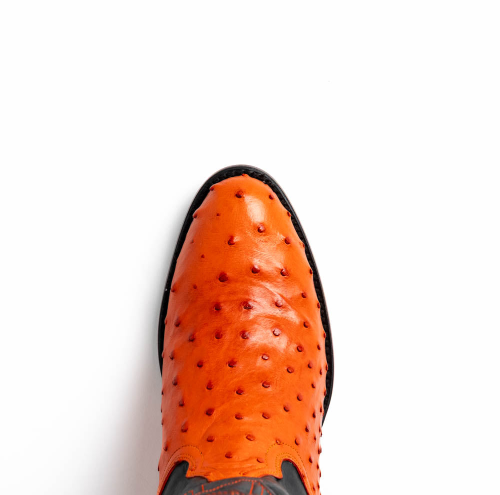 The Savannah Orange boots by Marco Di Milano feature orange ostrich leather lowers, black genuine leather uppers, intricate stitching, and branded soles.