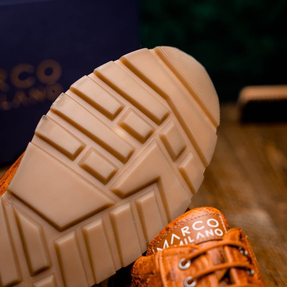 The Scanno Antique Cognac by Marco Di Milano is a brown leather sneaker with an ostrich-patterned, hand-painted finish, white midsole, brown outsole, and brand logo on the tongue—ideal for genuine ostrich quill sneaker fans. Photographed on a plain background.