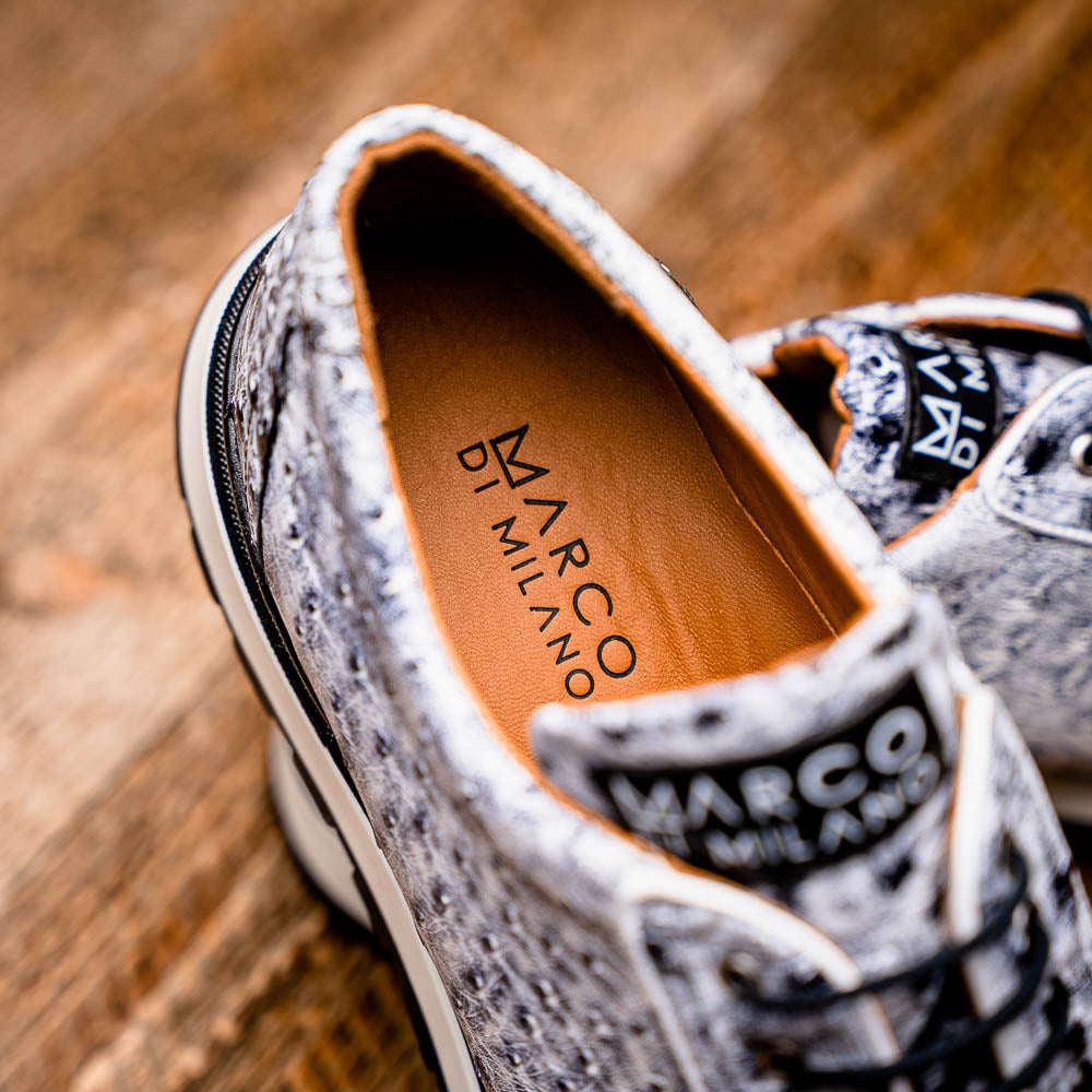 The Marco Di Milano Scanno Newspaper sneakers feature a luxurious hand-painted white and black textured lace-up design with thick black rubber soles, displayed against a plain white background.