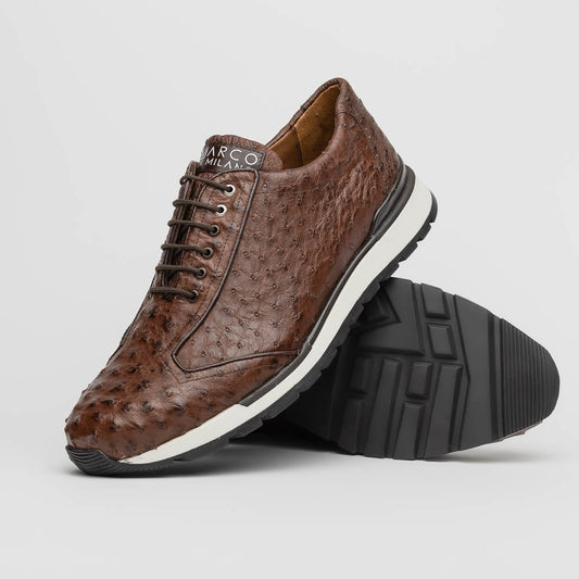 The Scanno Antique Brown sneaker by Marco Di Milano features genuine ostrich quill leather in brown, black laces, and a white-and-black rubber sole. One shoe stands upright while the other rests on its side, highlighting the hand-painted finish.