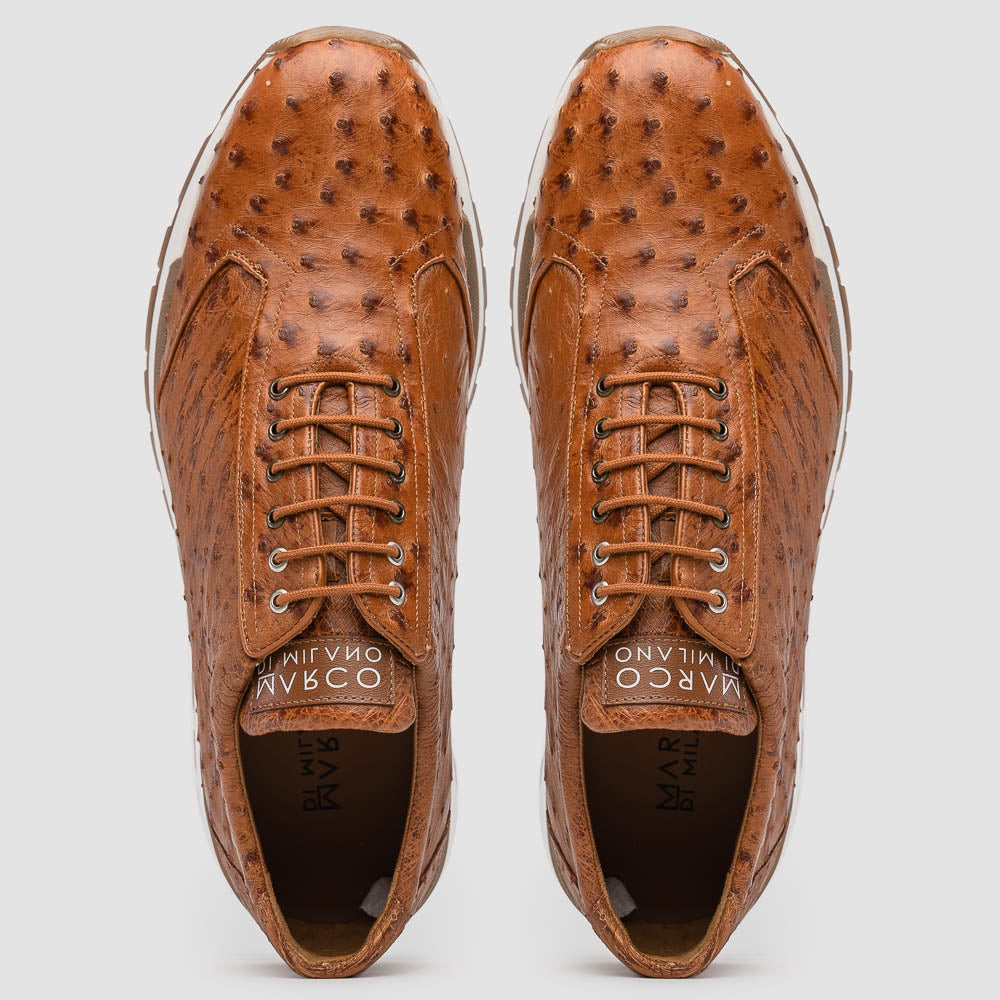 The Scanno Antique Cognac by Marco Di Milano is a brown leather sneaker with an ostrich-patterned, hand-painted finish, white midsole, brown outsole, and brand logo on the tongue—ideal for genuine ostrich quill sneaker fans. Photographed on a plain background.