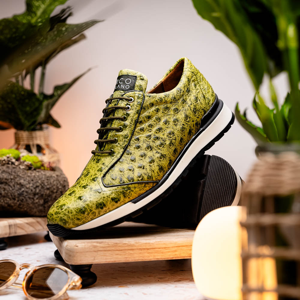 The Marco Di Milano Scanno Antique Green sneakers feature textured genuine ostrich quill in green, black laces, and white soles, with one shoe upright and the other propped beneath—exuding luxury footwear style.