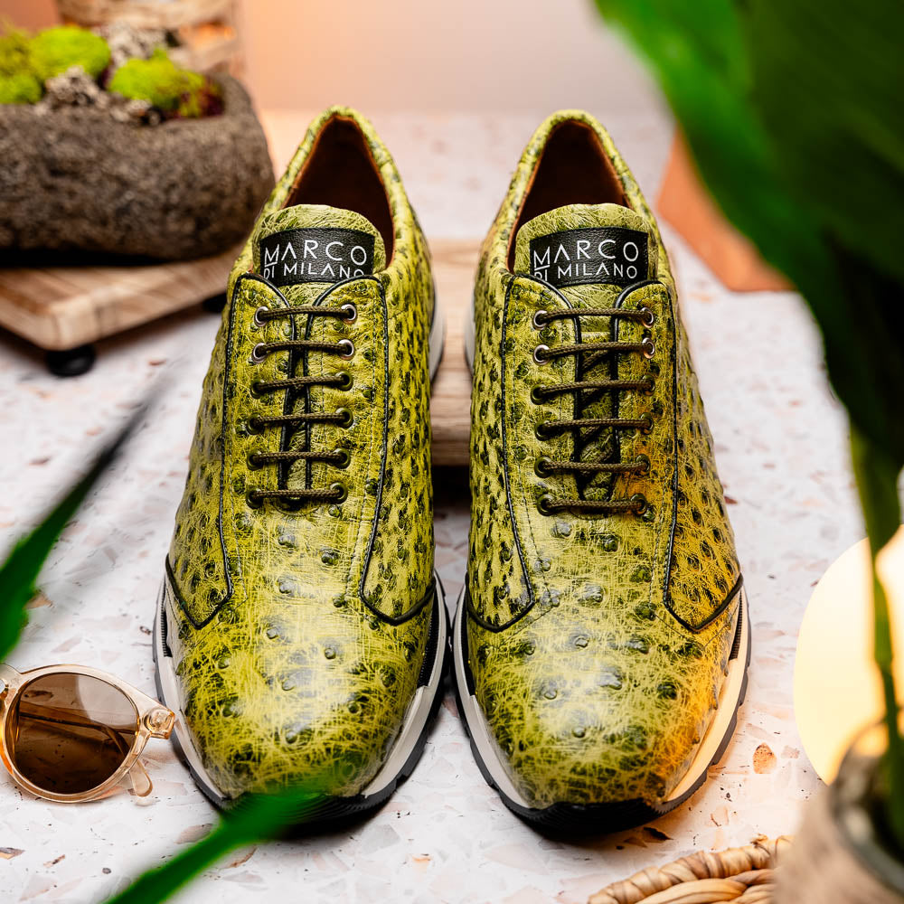 The Marco Di Milano Scanno Antique Green sneakers feature textured genuine ostrich quill in green, black laces, and white soles, with one shoe upright and the other propped beneath—exuding luxury footwear style.