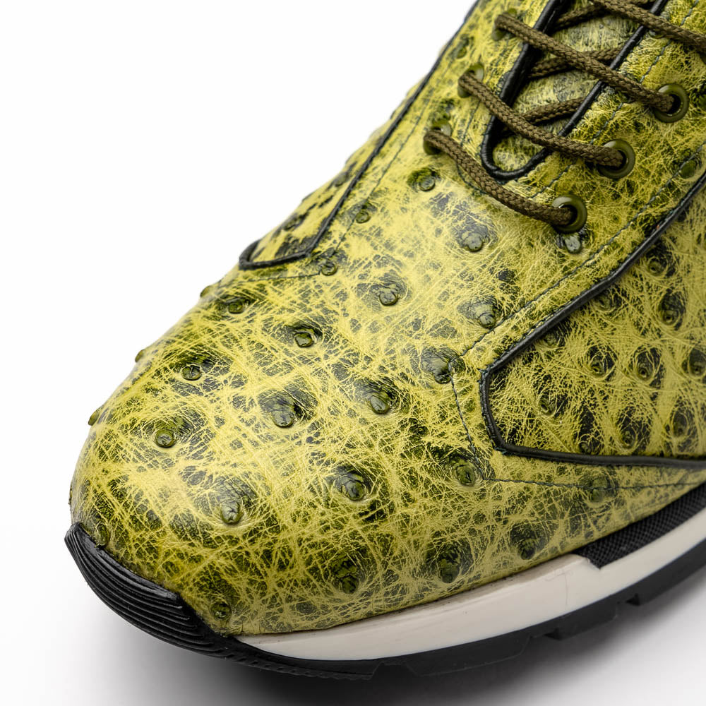 The Marco Di Milano Scanno Antique Green sneakers feature textured genuine ostrich quill in green, black laces, and white soles, with one shoe upright and the other propped beneath—exuding luxury footwear style.