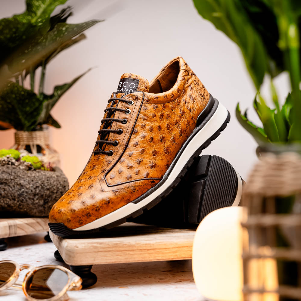 The Scanno Antique Paja sneakers by Marco Di Milano feature real ostrich quill leather with a hand-painted finish, brown leather, black laces, and white-accented soles—one shoe propped on the other against a white background.