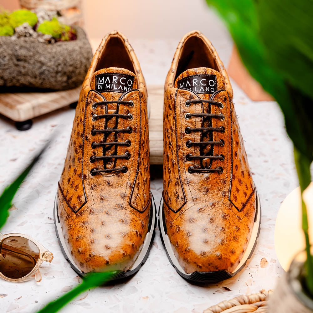 The Scanno Antique Paja sneakers by Marco Di Milano feature real ostrich quill leather with a hand-painted finish, brown leather, black laces, and white-accented soles—one shoe propped on the other against a white background.