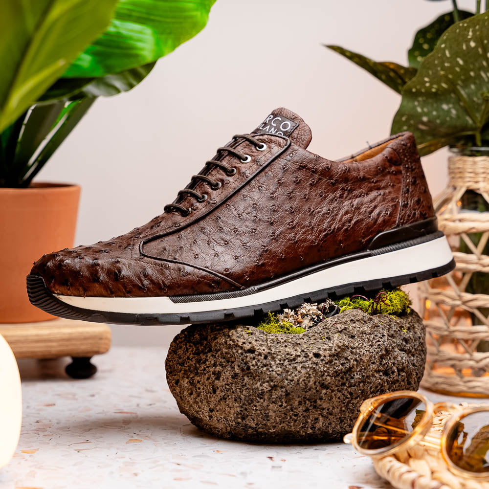 The Scanno Antique Brown sneaker by Marco Di Milano features genuine ostrich quill leather in brown, black laces, and a white-and-black rubber sole. One shoe stands upright while the other rests on its side, highlighting the hand-painted finish.