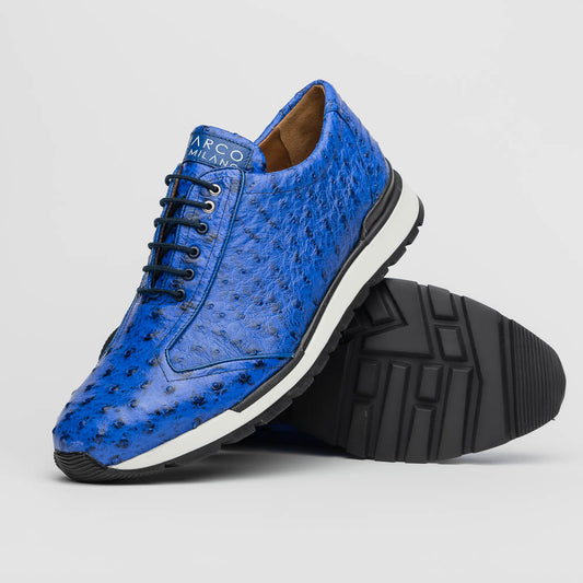 The Scanno Electric Blue sneakers by Marco Di Milano feature textured blue leather, black laces, white soles, and a hand-painted finish—luxury footwear shown upright and leaning to display the black tread.