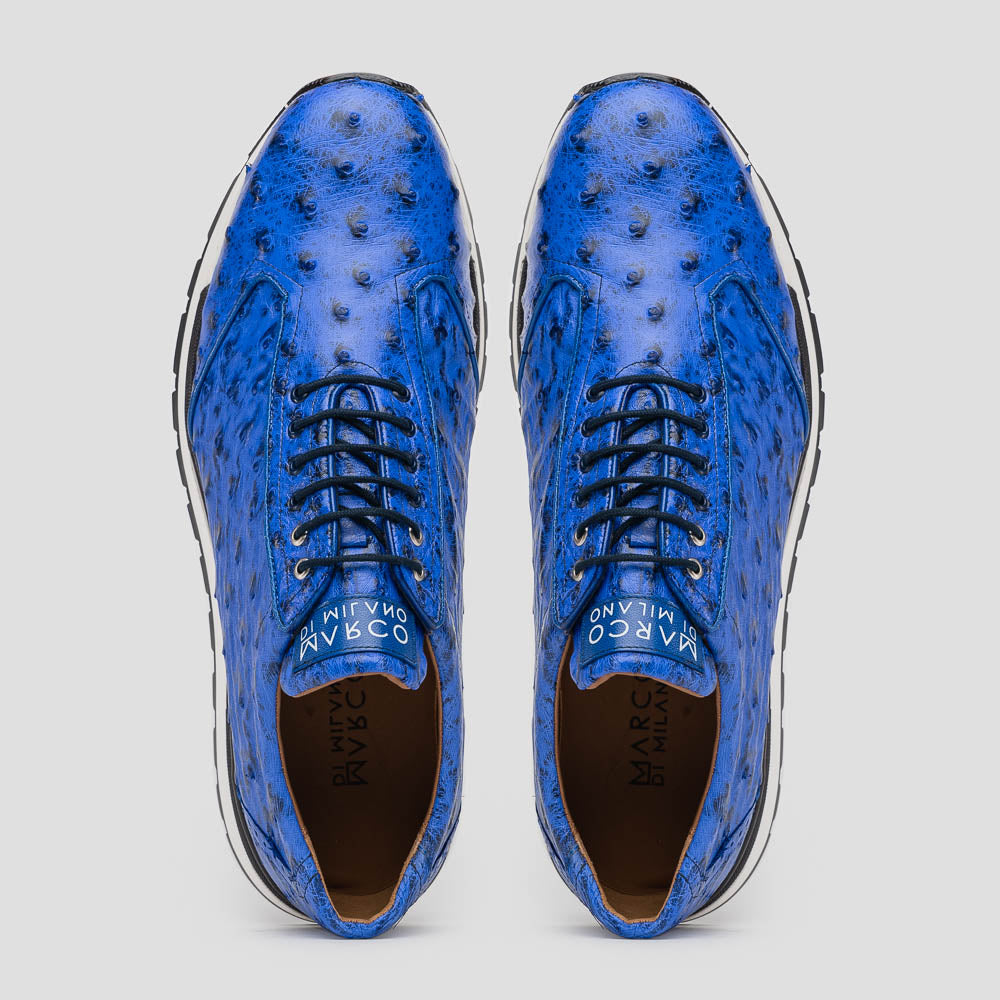 The Scanno Electric Blue sneakers by Marco Di Milano feature textured blue leather, black laces, white soles, and a hand-painted finish—luxury footwear shown upright and leaning to display the black tread.