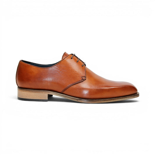 The Duca Sermoneta Cognac by Duca Di Matiste, a classic brown Italian leather dress shoe with a low wooden heel and black lining, is shown in a side view against a white background, highlighting its timeless elegance.